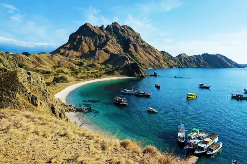 Luxury phinisi boat sailing in Labuan Bajo under sunset sky for New Year trip